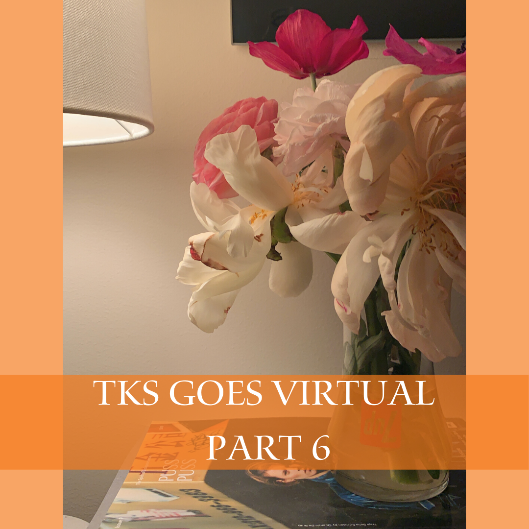 A lamp illuminates a vase of pink and white flowers on a table, casting a cozy glow. An orange band across the image reads "TKS Goes Virtual Part 6." Beneath the vase, a book or magazine rests, offering a student perspective on the struggle and joy of virtual classes.