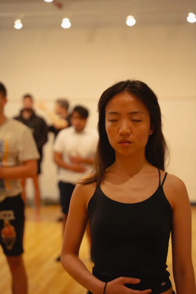 Voice teacher guiding actors through breath and vocal awareness exercises